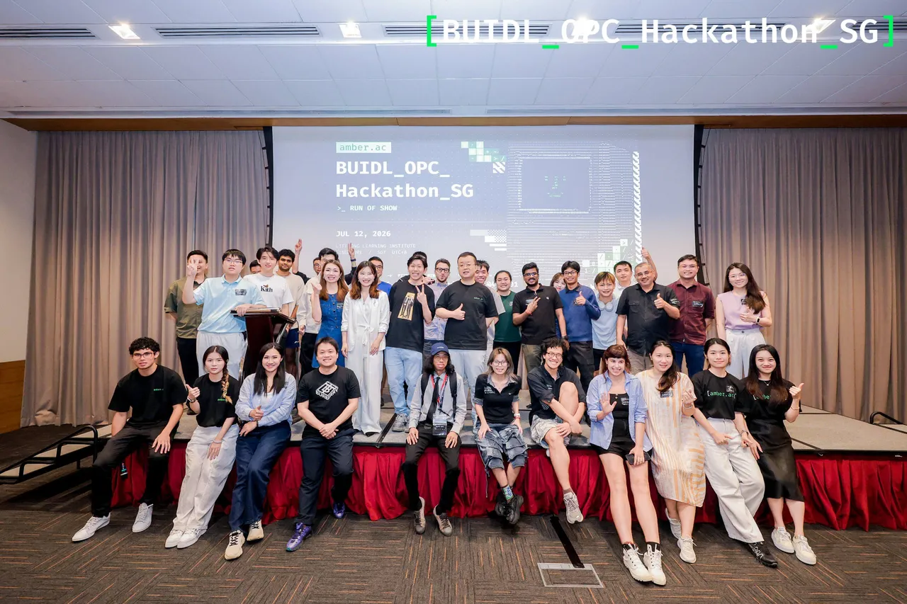 A group of builders and organisers in front of the BUIDL OPC Hackathon SG stage, with the run-of-show slide behind them.